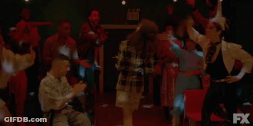 A Group Of People Are Dancing In A Dark Room In Front Of An Fx Logo . GIF