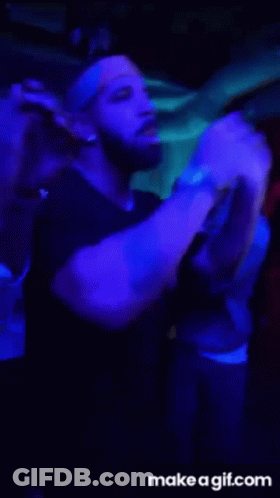A Group Of People Are Dancing In A Dark Room With Blue Lights .. GIF