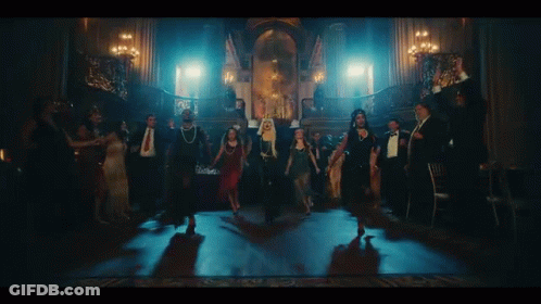 A Group Of People Are Dancing In A Dark Room With Candles . GIF