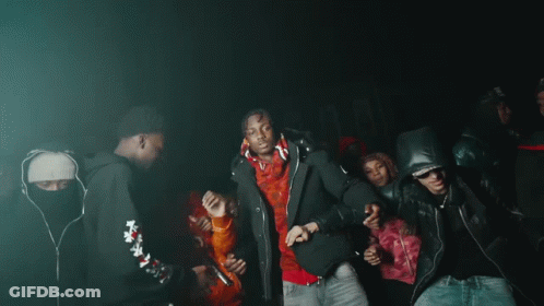 A Group Of People Are Dancing In A Dark Room With Purple Lights GIF