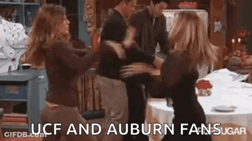 A Group Of People Are Dancing In A Kitchen With The Words `` Ucf And Auburn Fans Sugar '' Written Above Them . GIF
