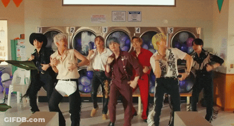 A Group Of People Are Dancing In A Laundromat With Numbers 1 2 3 4 And 5 On The Washers GIF