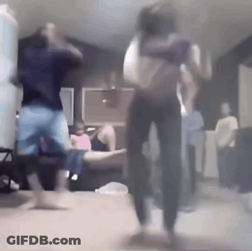 A Group Of People Are Dancing In A Living Room While A Man Holds A Baby . GIF