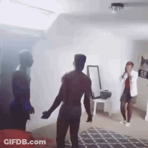 A Group Of People Are Dancing In A Living Room With Smoke Coming Out Of The Window . GIF