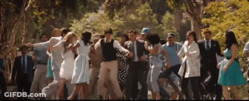 A Group Of People Are Dancing In A Park GIF