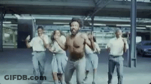 A Group Of People Are Dancing In A Parking Lot . GIF