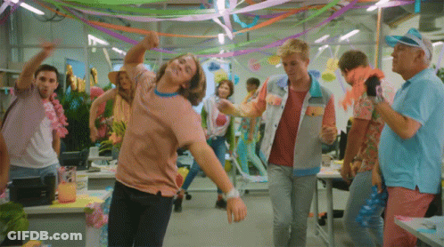 A Group Of People Are Dancing In A Room Decorated With Colorful Ribbons GIF