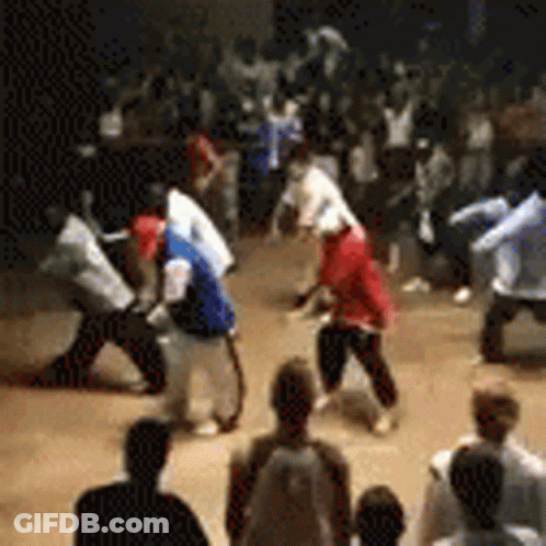 A Group Of People Are Dancing In A Room While A Crowd Watches . GIF