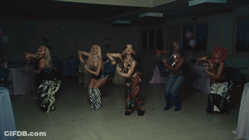 A Group Of People Are Dancing In A Room With A Blue Bag That Says Hawaii GIF