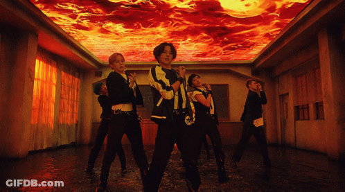 A Group Of People Are Dancing In A Room With A Ceiling That Is On Fire GIF