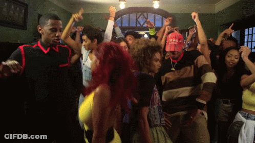 A Group Of People Are Dancing In A Room With A Man Wearing A Hat That Says 1994 GIF