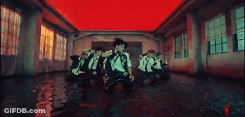 A Group Of People Are Dancing In A Room With A Red Ceiling . GIF