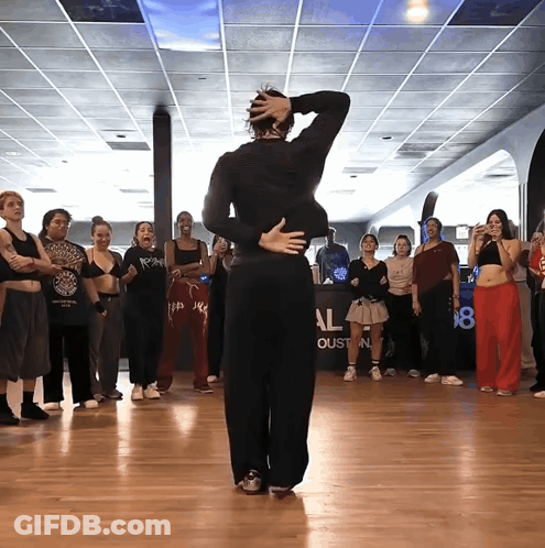 A Group Of People Are Dancing In A Room With A Sign That Says Al GIF