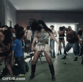 A Group Of People Are Dancing In A Room With A Woman Wearing A Number 2 Shirt On GIF