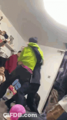 A Group Of People Are Dancing In A Room With Balloons . One Of The People Is Wearing A Green Jacket . GIF