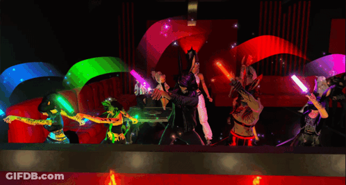 A Group Of People Are Dancing In A Room With Glow In The Dark Sticks GIF