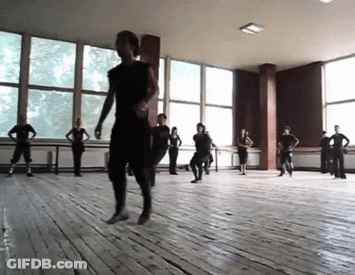 A Group Of People Are Dancing In A Room With Many Windows GIF