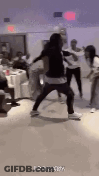 A Group Of People Are Dancing In A Room With Tables And Chairs . GIF