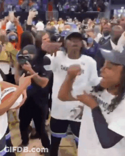 A Group Of People Are Dancing In A Stadium And One Of Them Is Wearing A Shirt That Says Champions GIF