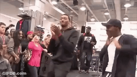 A Group Of People Are Dancing In A Store In Front Of A Crowd Of People . GIF