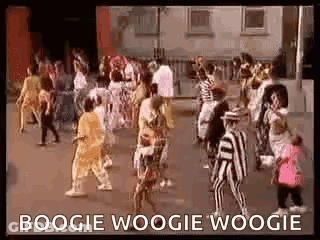 A Group Of People Are Dancing In A Street In Front Of A Building And A Sign That Says Boogie Woogie Woogie . GIF
