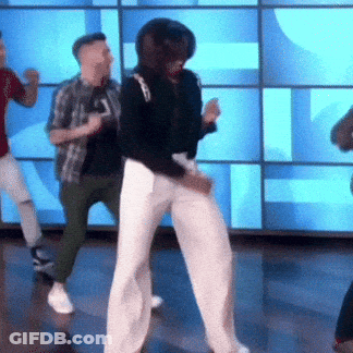 A Group Of People Are Dancing In Front Of A Blue Wall . GIF