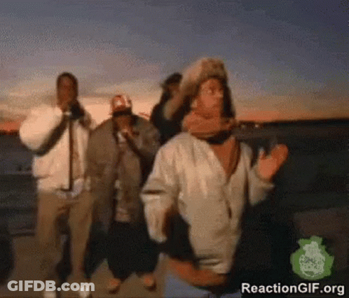 A Group Of People Are Dancing In Front Of A Body Of Water GIF
