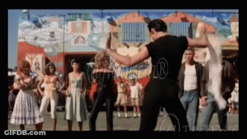 A Group Of People Are Dancing In Front Of A Building With A Mural On The Wall GIF