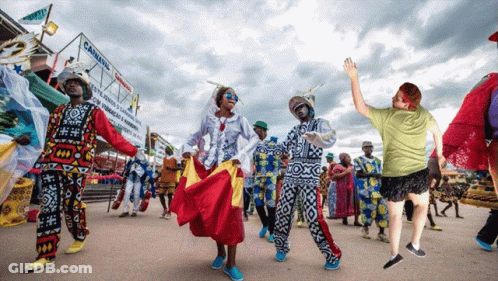 A Group Of People Are Dancing In Front Of A Canning Sign GIF