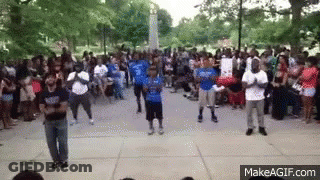 A Group Of People Are Dancing In Front Of A Crowd Of People . GIF