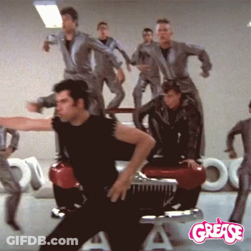 A Group Of People Are Dancing In Front Of A Grease Logo GIF
