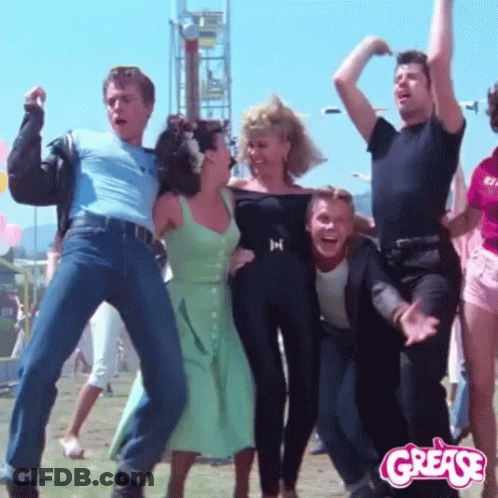 A Group Of People Are Dancing In Front Of A Grease Sign GIF