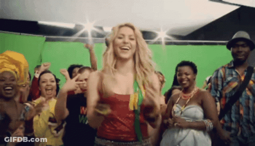 A Group Of People Are Dancing In Front Of A Green Screen And One Of Them Has The Letter M On Their Shirt GIF