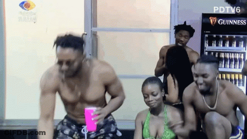 A Group Of People Are Dancing In Front Of A Guinness Cooler GIF