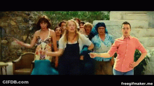 A Group Of People Are Dancing In Front Of A Man In A Red Shirt . GIF