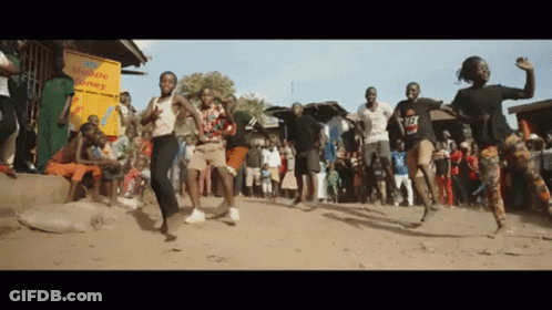 A Group Of People Are Dancing In Front Of A Mobile Money Store GIF