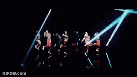 A Group Of People Are Dancing In Front Of A Neon Sign That Says Baby GIF