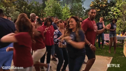 A Group Of People Are Dancing In Front Of A Netflix Ad GIF