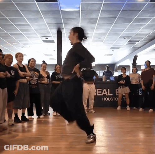 A Group Of People Are Dancing In Front Of A Real Houston Sign GIF