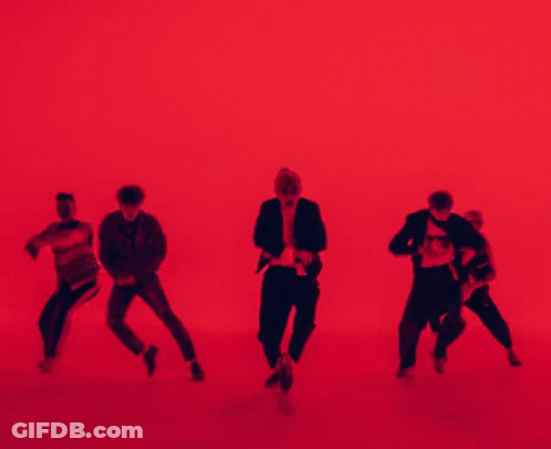 A Group Of People Are Dancing In Front Of A Red Background . GIF