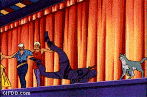 A Group Of People Are Dancing In Front Of A Red Curtain And A Cat GIF