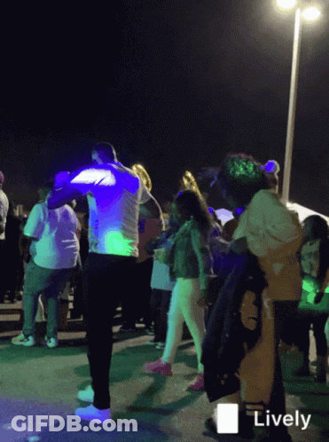 A Group Of People Are Dancing In Front Of A Sign That Says " Lively " GIF