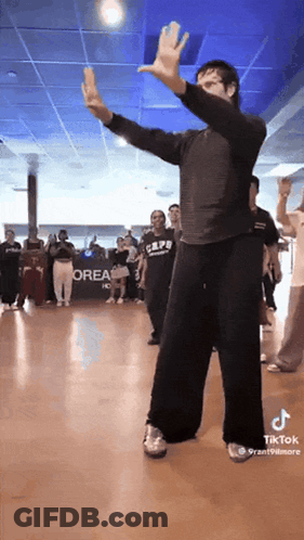 A Group Of People Are Dancing In Front Of A Sign That Says Orea On It GIF
