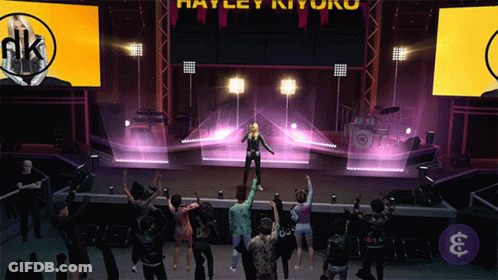 A Group Of People Are Dancing In Front Of A Stage That Says Harley Ryu On It GIF