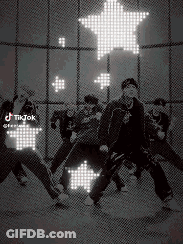 A Group Of People Are Dancing In Front Of A Star Shaped Light . GIF