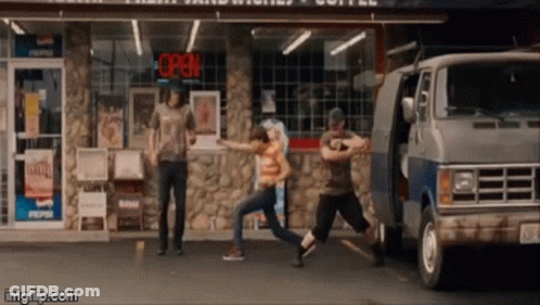 A Group Of People Are Dancing In Front Of A Store With An Open Sign Above Them GIF
