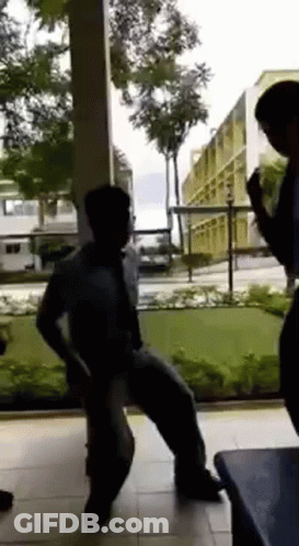 A Group Of People Are Dancing In Front Of A Window . GIF