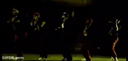 A Group Of People Are Dancing In The Dark In A Dark Room . GIF