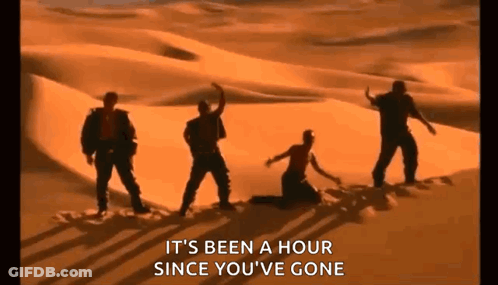 A Group Of People Are Dancing In The Desert While A Woman Is Kneeling Down . GIF