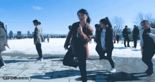 A Group Of People Are Dancing In The Snow And One Of Them Is Wearing A Sweatshirt That Says Guess GIF